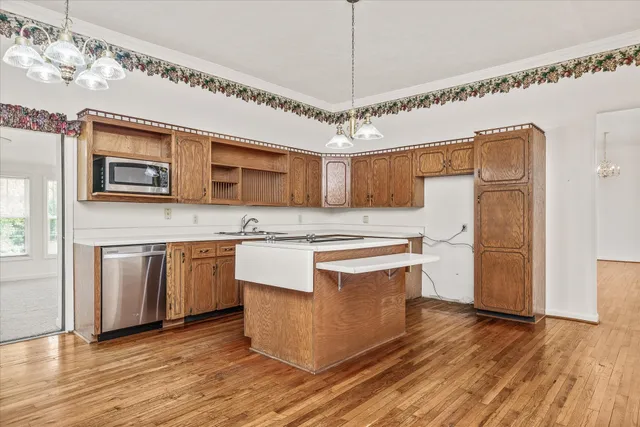 an empty room with chandelier fan and windows