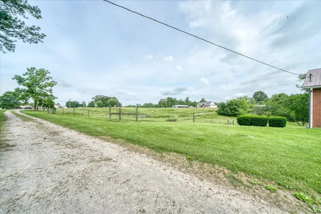 a view of a house with a yard and potted plants