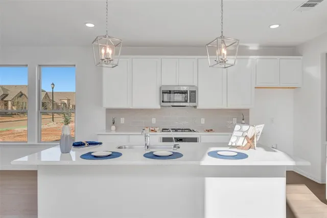 a kitchen with a sink a window and chairs