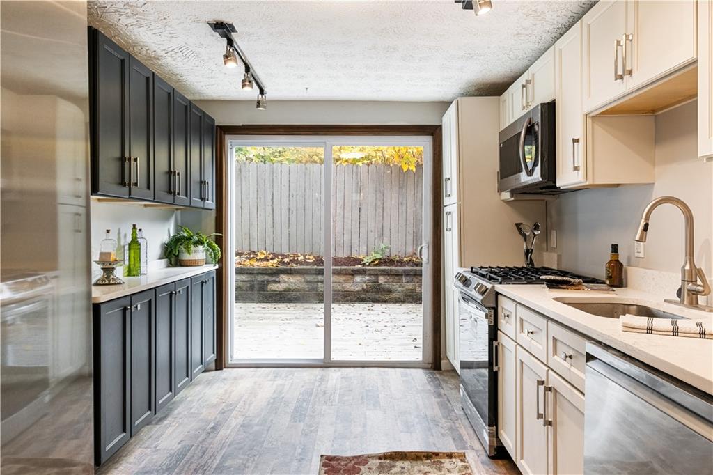 179 Merrimac Street Pittsburgh, PA 15211 - Photo 14 of 37 a kitchen with stainless steel appliances granite countertop a stove a sink and a refrigerator