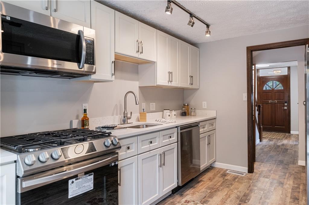 179 Merrimac Street Pittsburgh, PA 15211 - Photo 16 of 37 a kitchen with stainless steel appliances a sink a stove and microwave