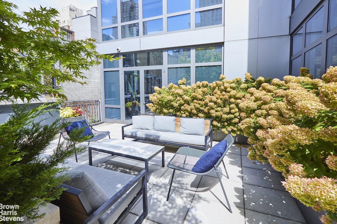 310 West 52nd Street, Unit 5B Manhattan, NY 10019 - Photo 10 of 15 a view of a patio with table and chairs and potted plants
