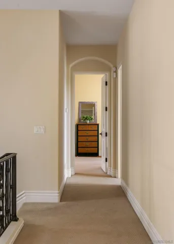 a view of a hallway with wooden floor and a white cabinet