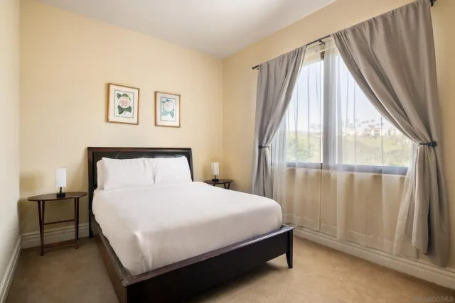 a bedroom with a bed and a large window