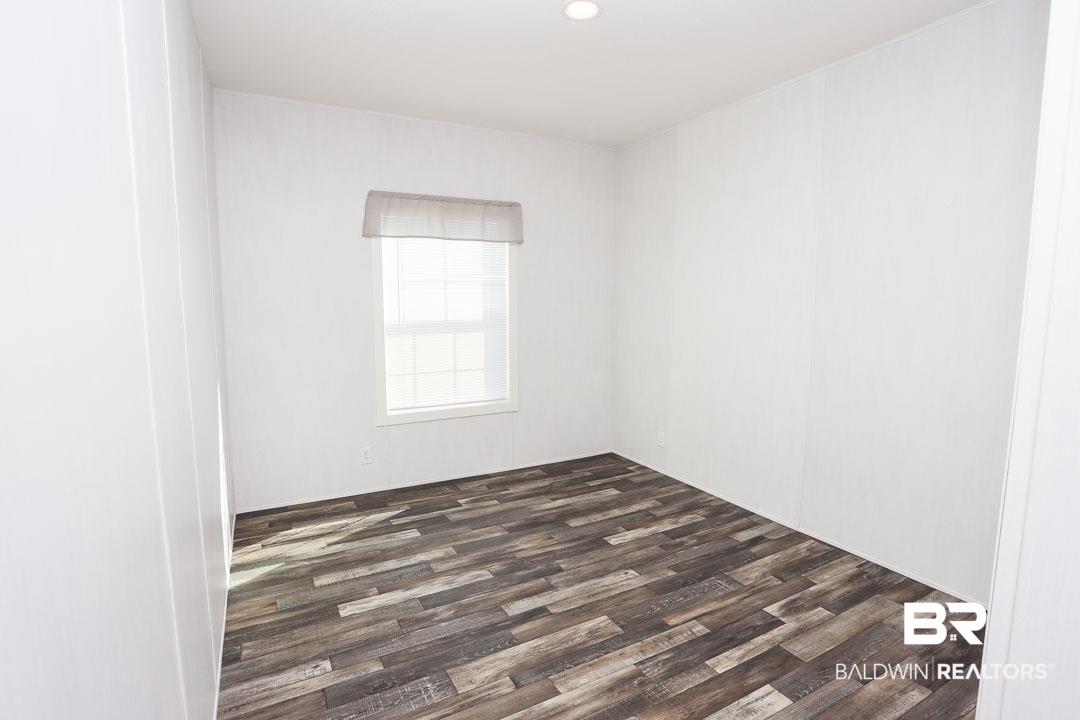 19180 Horseshoe Circle Seminole, AL 36574 - Photo 22 of 38 Empty room featuring dark wood-type flooring and recessed lighting