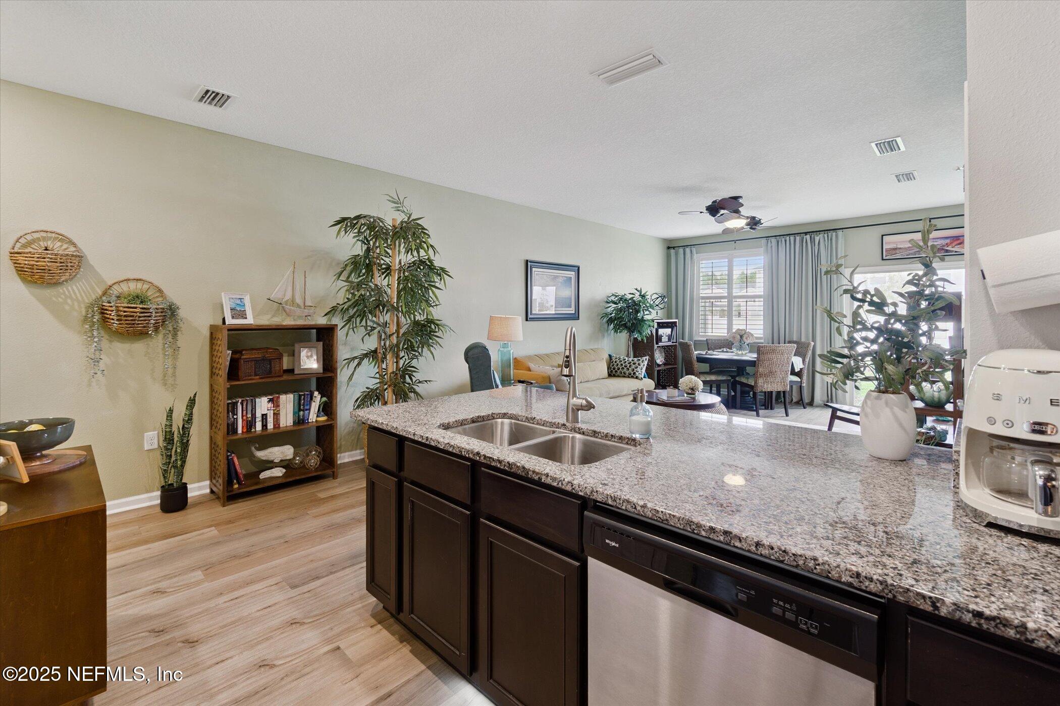 7821 Merchants Way Jacksonville, FL 32222 - Photo 12 of 35 a kitchen with granite countertop a sink dishwasher stove and cabinets