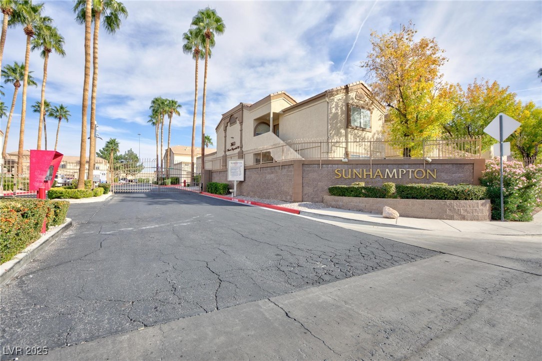 3673 Ian Thomas Street, Unit 102 Las Vegas, NV 89129 - Photo 15 of 15 View of asphalt road with curbs, a gated entry, sidewalks, and a gate