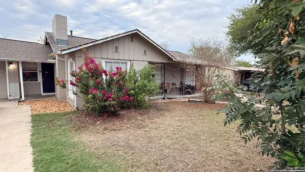 a front view of a house with a yard and potted plants