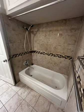 a bath tub sitting next to a white sink and vanity