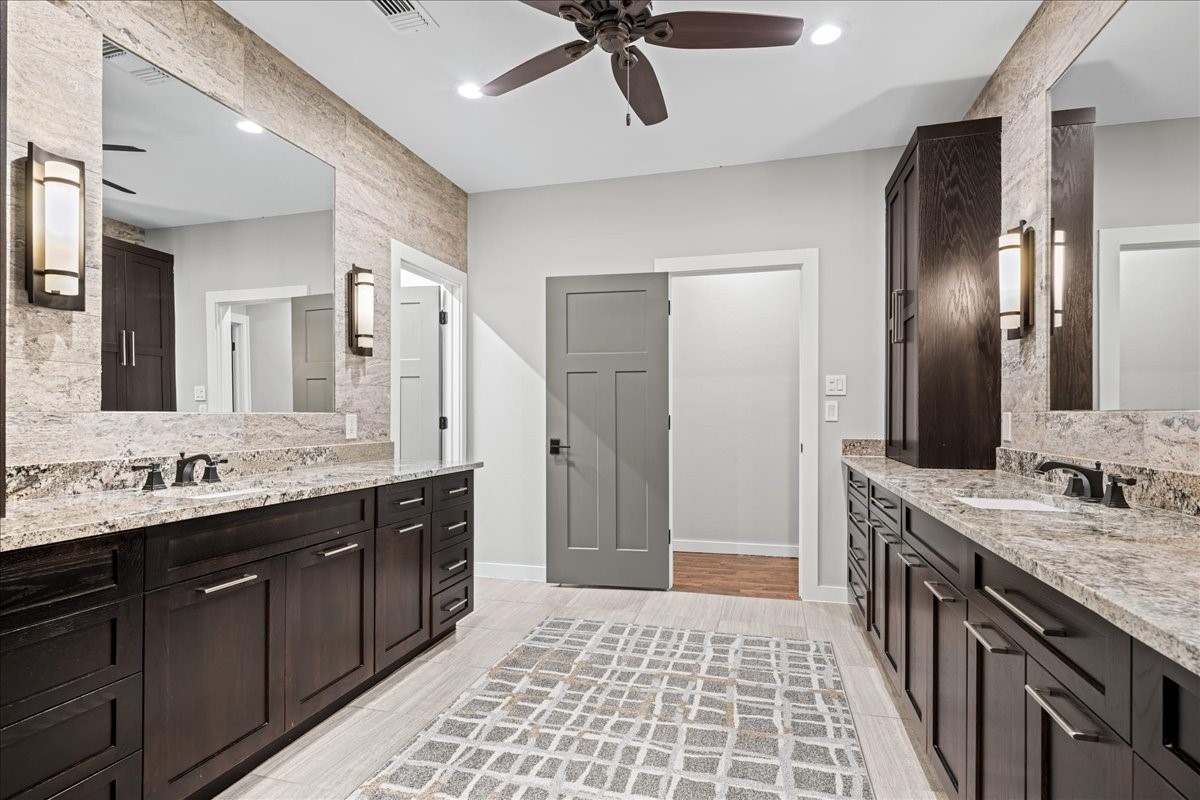 1502 Reimer Street Brenham, TX 77833 - Photo 17 of 30 a bathroom with a double vanity sink and a mirror