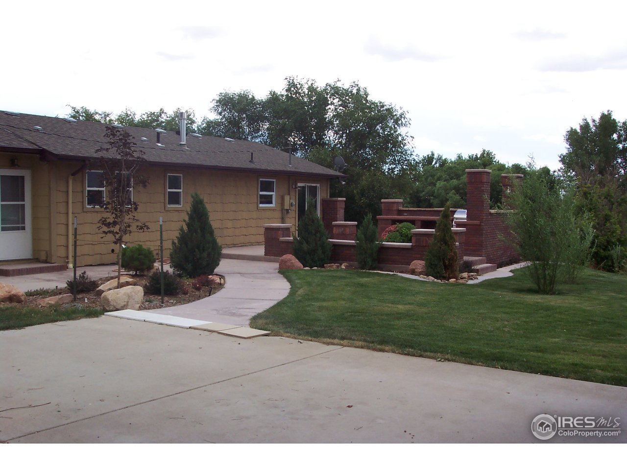 6825 East County Line Road Longmont, CO 80504 - Photo 4 of 22 a backyard of a house with barbeque oven and outdoor seating