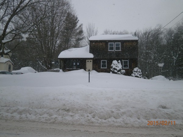 a view of a house with a yard covered with snow in the background