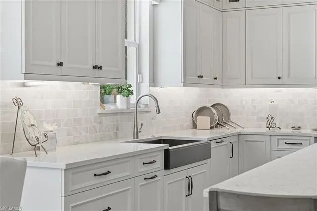 a kitchen with granite countertop white cabinets and white appliances