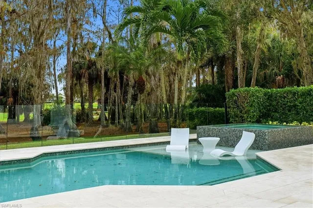 a view of a fountain in the yard with palm trees