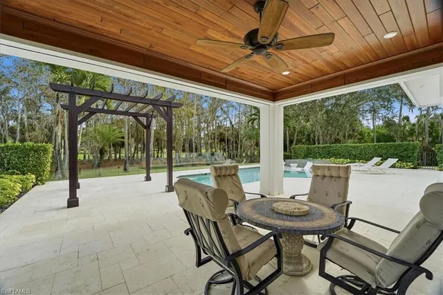 a view of a patio with a table chairs and a backyard