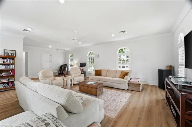 a living room with furniture a wooden floor and a flat screen tv