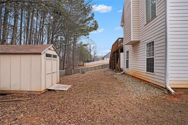 a view of a house with backyard and trees