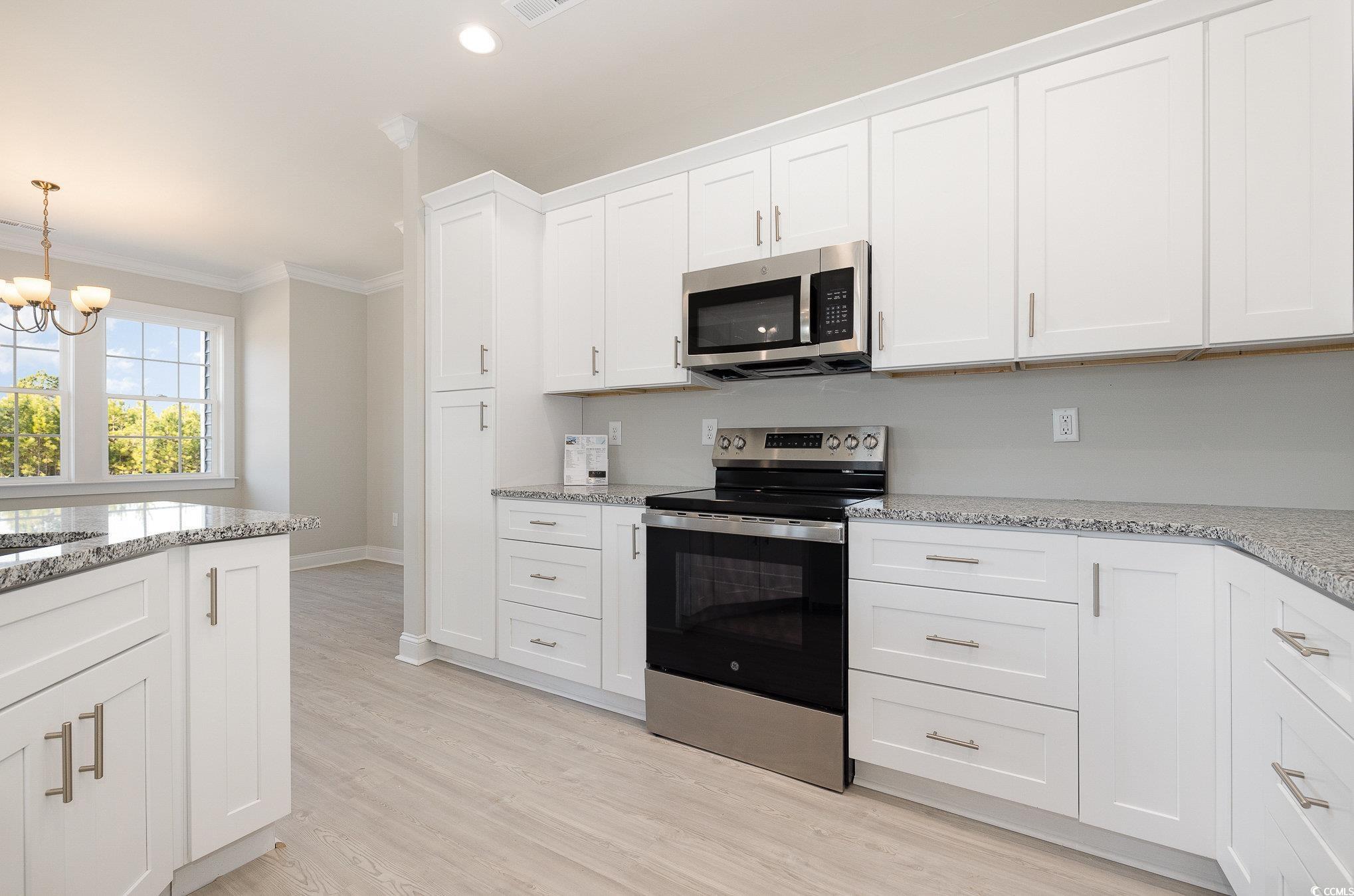 381 Log Cabin Road Loris, SC 29569 - Photo 14 of 35 Kitchen with white cabinets, decorative light fixt