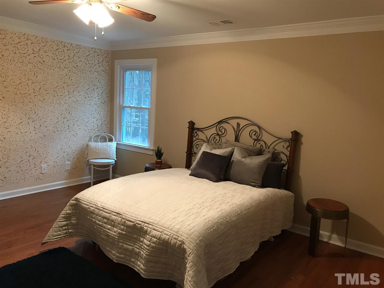 1416 Shadowview Court Raleigh, NC 27614 - Photo 11 of 28 a bedroom with a bed and a chandelier