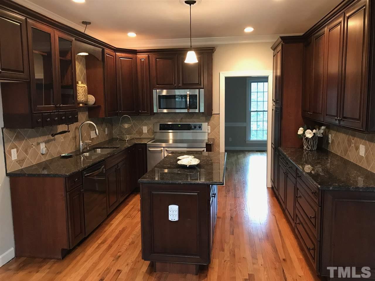 1416 Shadowview Court Raleigh, NC 27614 - Photo 5 of 28 a kitchen with kitchen island granite countertop stainless steel appliances a sink stove top oven and refrigerator