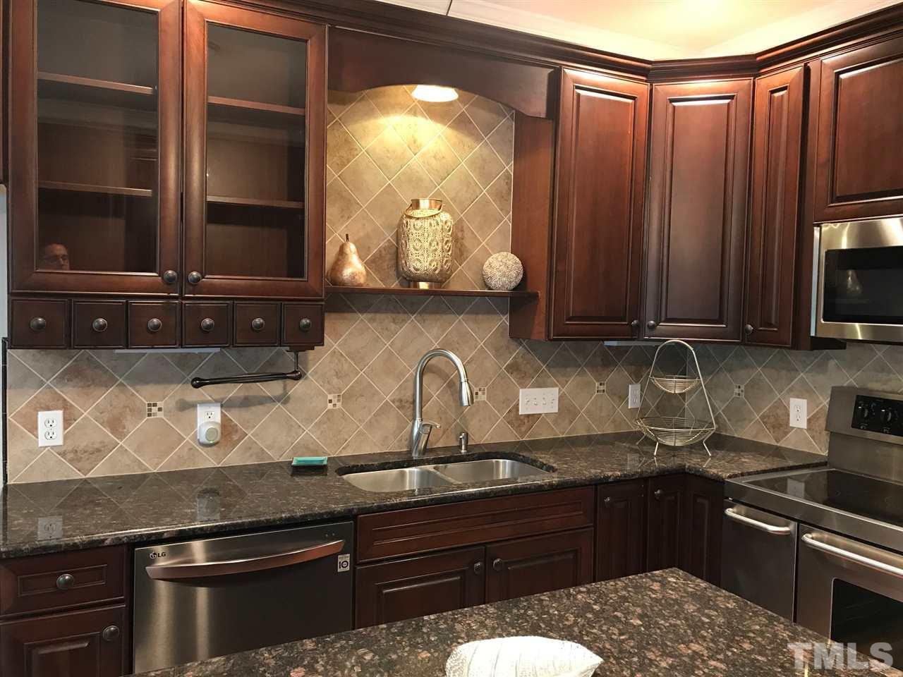 1416 Shadowview Court Raleigh, NC 27614 - Photo 6 of 28 a kitchen with granite countertop a stove and cabinets