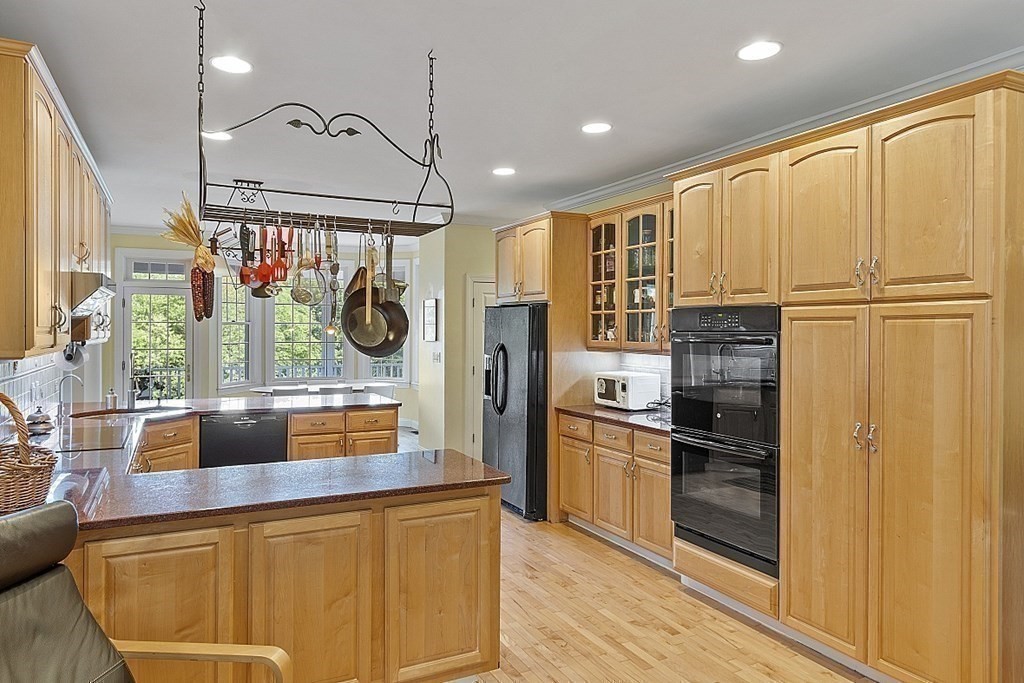 100 West Berlin Road Bolton, MA 01740 - Photo 17 of 42 a kitchen with stainless steel appliances granite countertop a refrigerator a oven a stove and a dining table with wooden floor