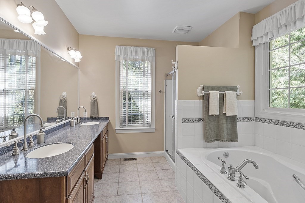100 West Berlin Road Bolton, MA 01740 - Photo 24 of 42 a bathroom with a granite countertop sink a large mirror and a bathtub