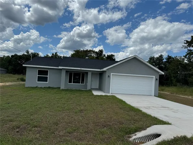 a front view of house with yard and trees