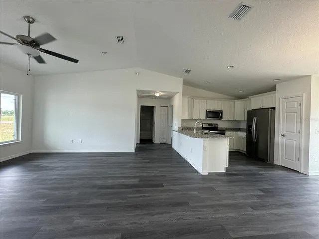 a view of kitchen with refrigerator stove microwave and cabinets
