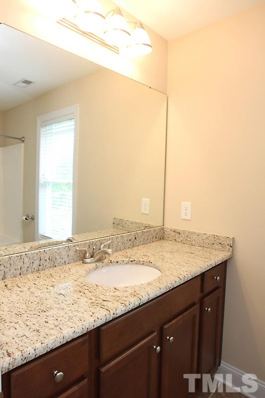 7332 Denlee Road Raleigh, NC 27603 - Photo 12 of 24 a bathroom with a granite countertop sink and a mirror