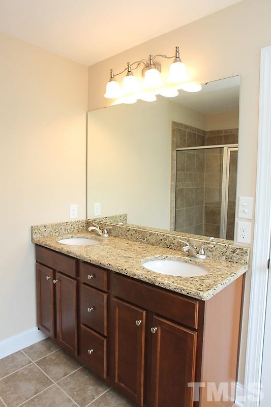 7332 Denlee Road Raleigh, NC 27603 - Photo 15 of 24 a bathroom with a granite countertop sink and a mirror