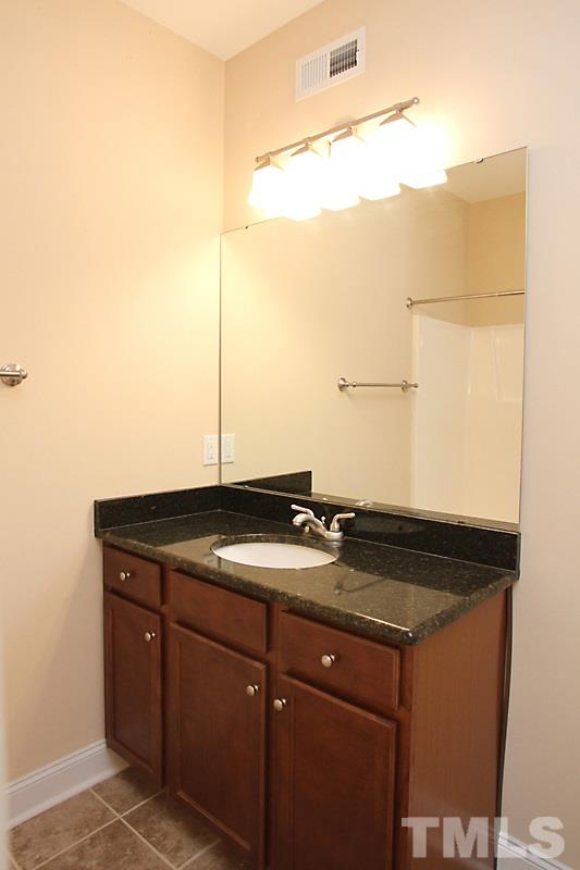 7332 Denlee Road Raleigh, NC 27603 - Photo 19 of 24 a bathroom with a granite countertop sink and a mirror