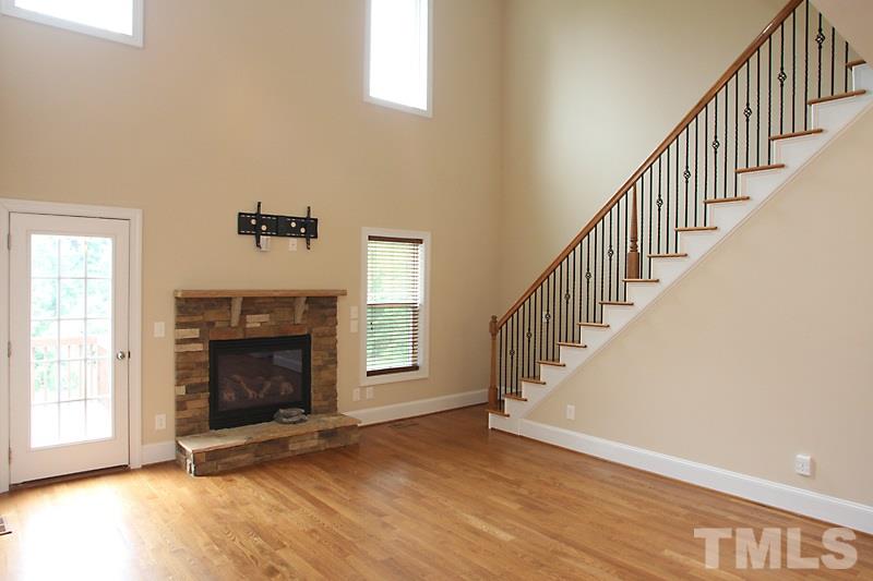7332 Denlee Road Raleigh, NC 27603 - Photo 5 of 24 a view of an empty room with wooden floor fireplace and a window