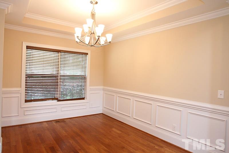 7332 Denlee Road Raleigh, NC 27603 - Photo 7 of 24 a view of an empty room with wooden floor and a window