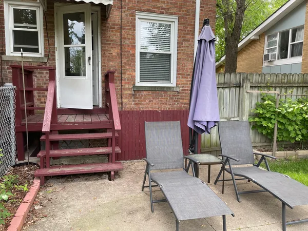 a view of backyard with table and chairs and wooden fence