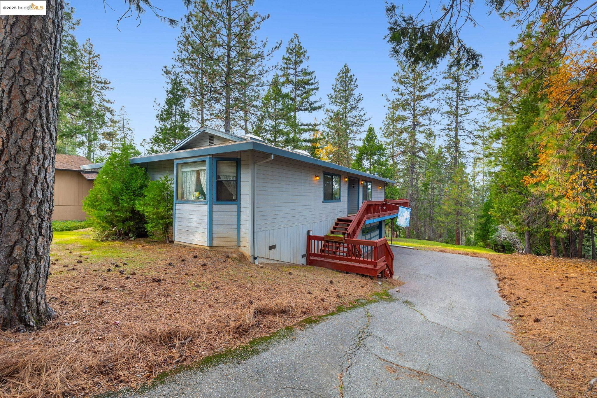 12087 Breckenridge Road Groveland, CA 95321 - Photo 2 of 31 a backyard of a house with wooden fence and trees