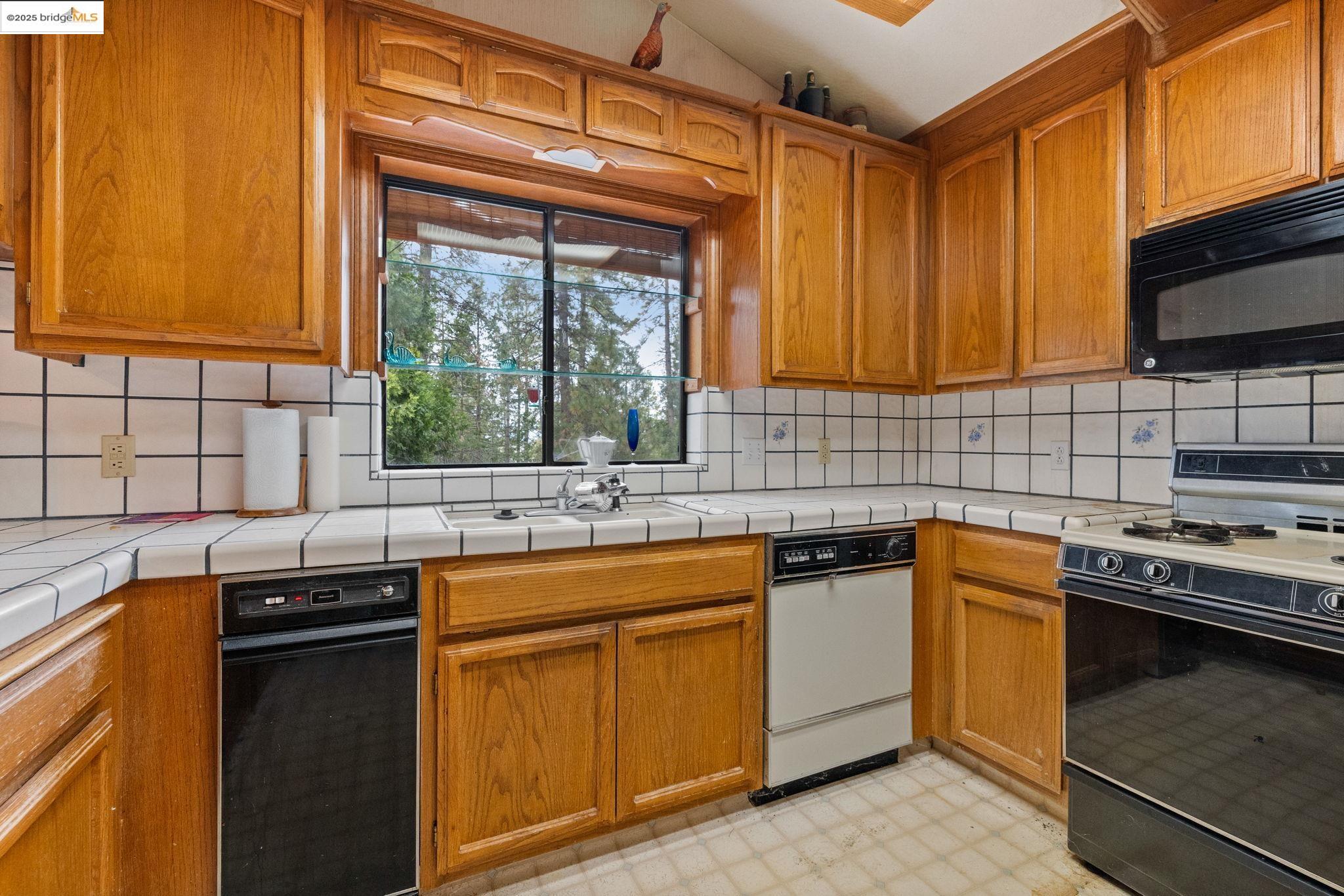 12087 Breckenridge Road Groveland, CA 95321 - Photo 10 of 31 a kitchen with stainless steel appliances a sink stove and cabinets
