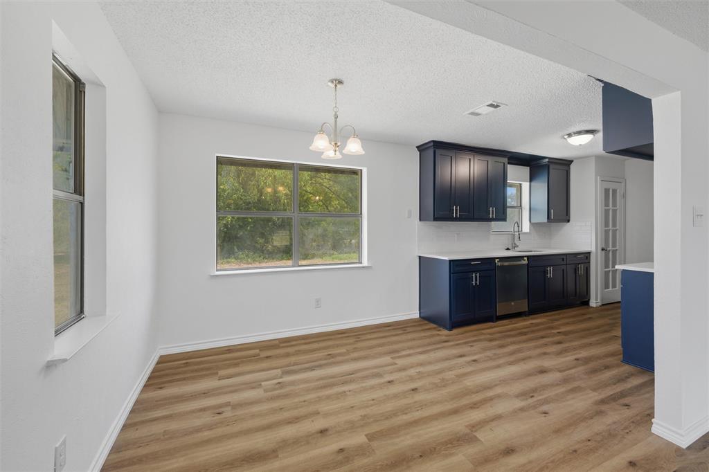 124 Prairie Creek Road Red Oak, TX 75154 - Photo 5 of 17 Open-concept kitchen and dining area featuring wood-finish flooring, white walls, and a window for natural light