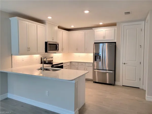 a kitchen with refrigerator and microwave