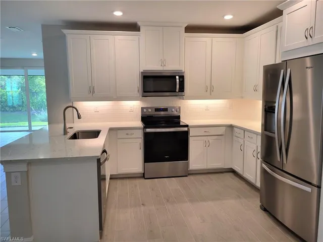 a kitchen with stainless steel appliances a refrigerator stove and microwave