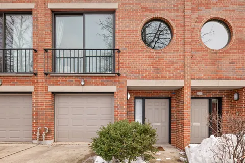 a front view of a house with a tree