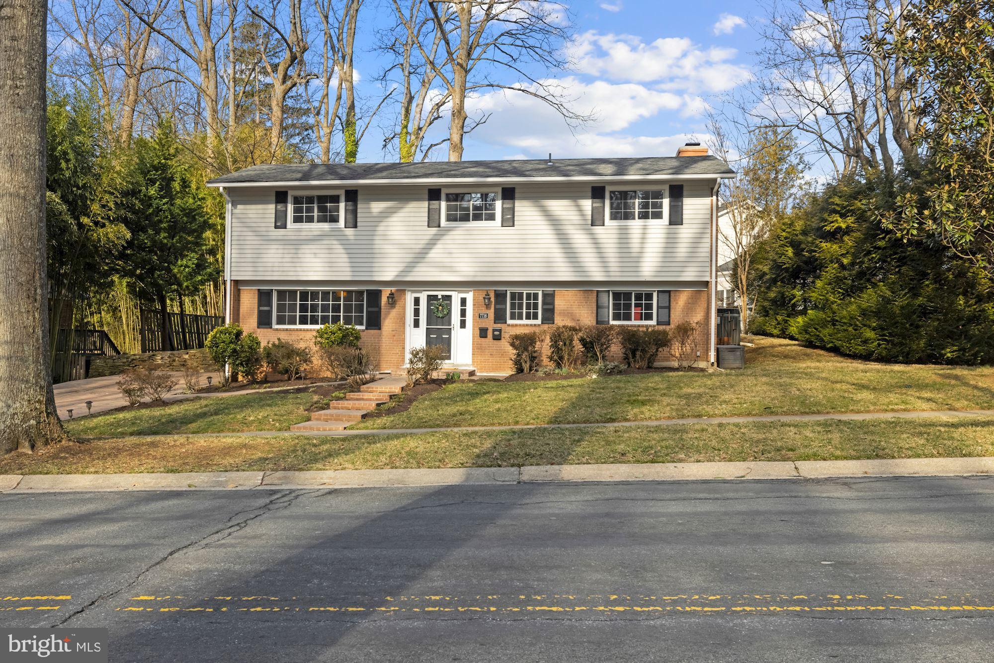 7716 Beech Tree Road Bethesda, MD 20817 - Photo 2 of 49 a front view of a house with a yard table and chairs