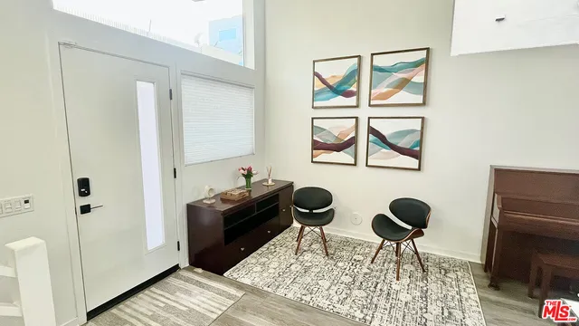 a view of a workspace room with furniture and window