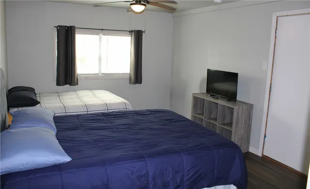 a bedroom with a bed flat screen tv and window