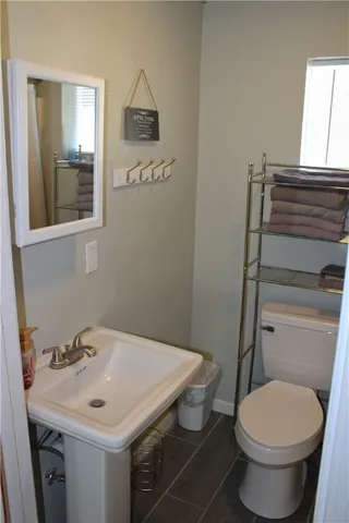 a bathroom with a toilet a sink and mirror