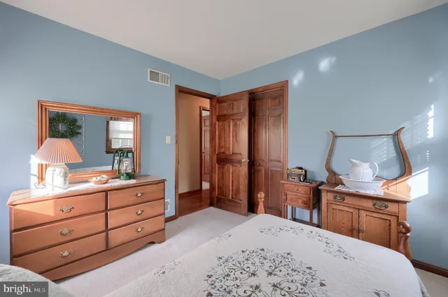 a room with a bed and a mirror on dresser