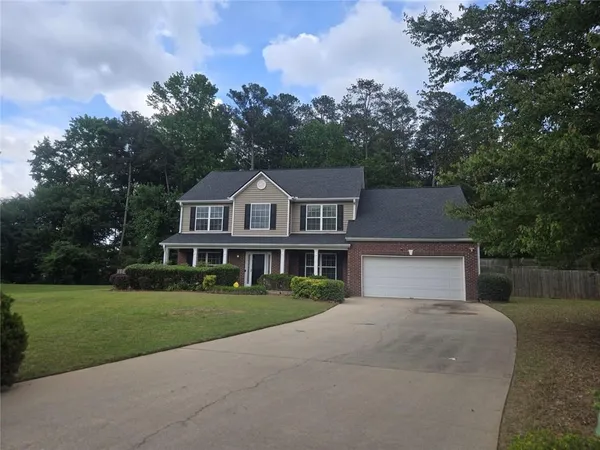 a front view of a house with a yard and trees