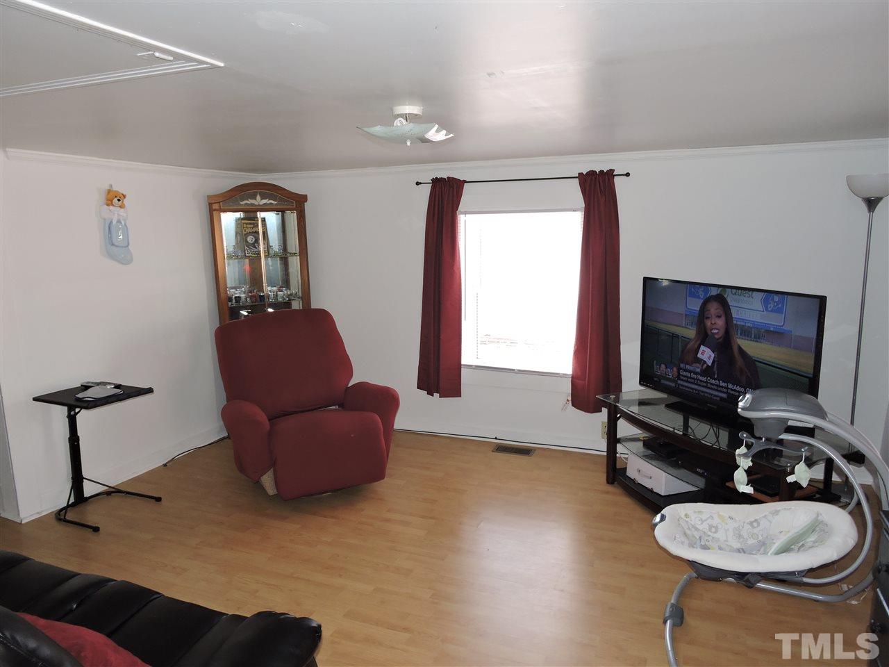 26 Raney Crumpton Road Roxboro, NC 27574 - Photo 2 of 7 a living room with furniture and a flat screen tv