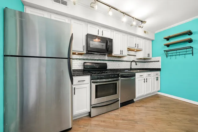 a kitchen with stainless steel appliances a refrigerator stove and microwave