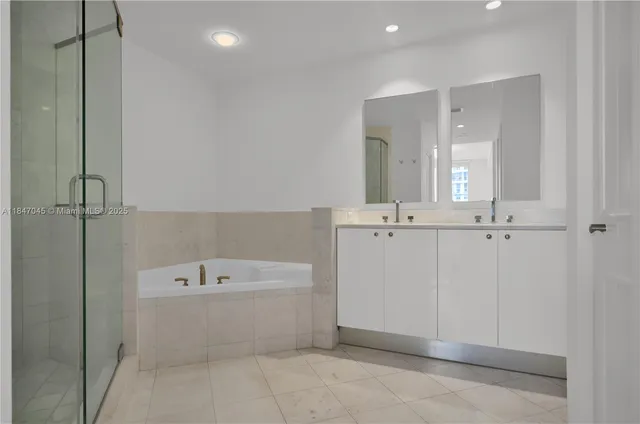 a bathroom with a bathtub a mirror a sink and vanity